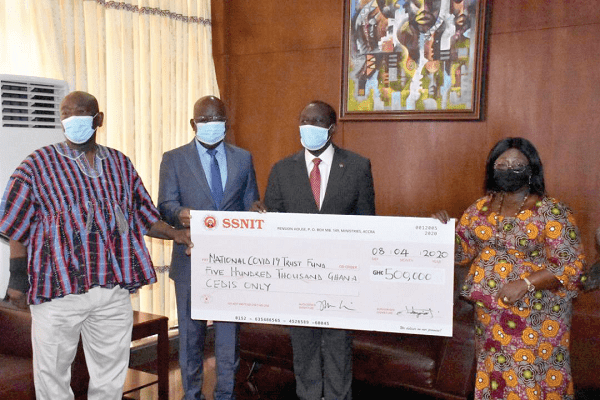 Dr Kwame Addo Kuffuor (2nd right) supported by Dr John Ofori-Tenkorang (2nd left), Director-General of SSNIT, and Mr Joshua Ansah, board member, to hand over the cheque to Mrs Frema Osei Opare