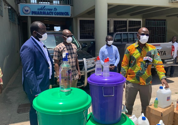 Mr Adjepong in suit presenting the items to Dr Rauf