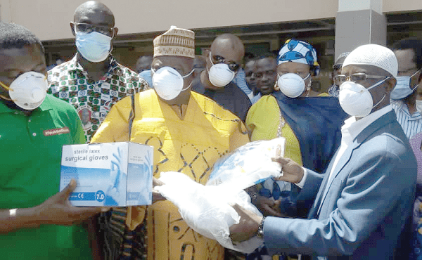 Alhaji Ibrahim Mobila (arrowed) presenting the PPE on behalf of Mr Mahama to Dr Mumuni (right), acting CEO of TTH