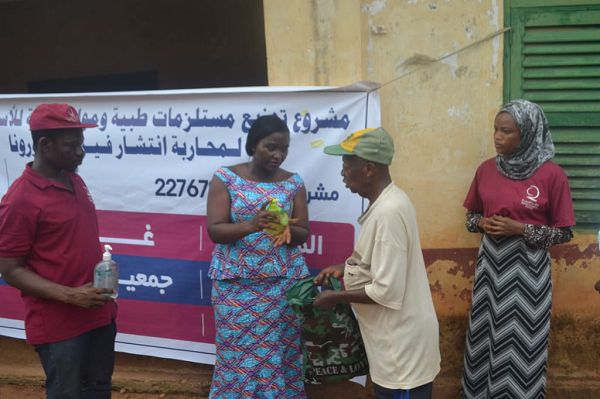 Mrs Justina Marigold Assan(2nd left), MCE for Agona West demonstrating how to use a liquid soap to a resident while Mr Ismail Sualah Laari of Qatar Charity look on.