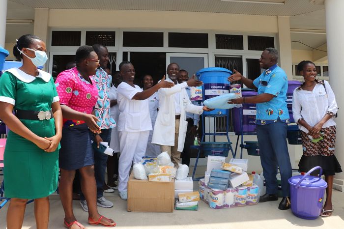Mr Ephrem Kwaa Aidoo(right), President of the Rotary Club of Winneba, presenting the items to Dr George Kwame Prah, the Medical Director of the hospital while other guests look on.