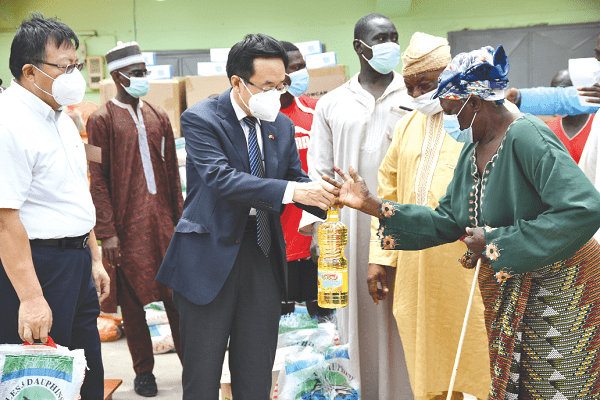 Mr Shi Ting Wang, handing over some of the food items to a beneficiary. Picture: EBOW HANSON