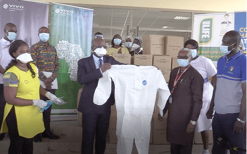 Dr Ali Samba (2nd left) showcasing one of the personal protective equipment he had received from Mr Ben Hassan Ouattara (2nd right)