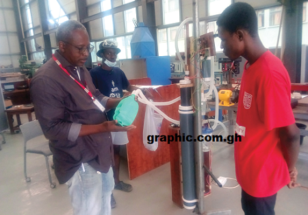 Professor Fred McBagonluri (left) explaining the functions of one of the ventilators. With him are Barnabas Nomo (2nd left) and Nathaniel Asiak (right), both engineering students  at Academic City