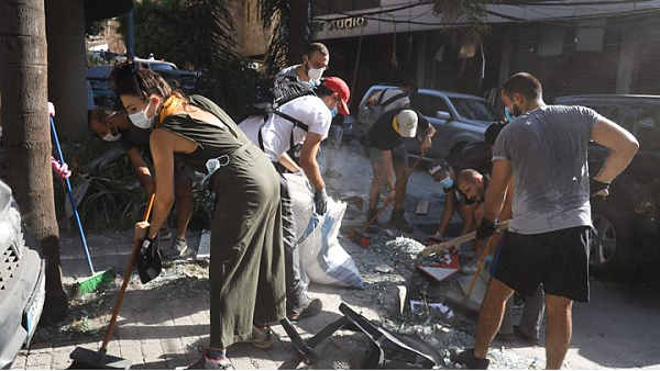 People in Beirut help clear the streets after deadly explosion
