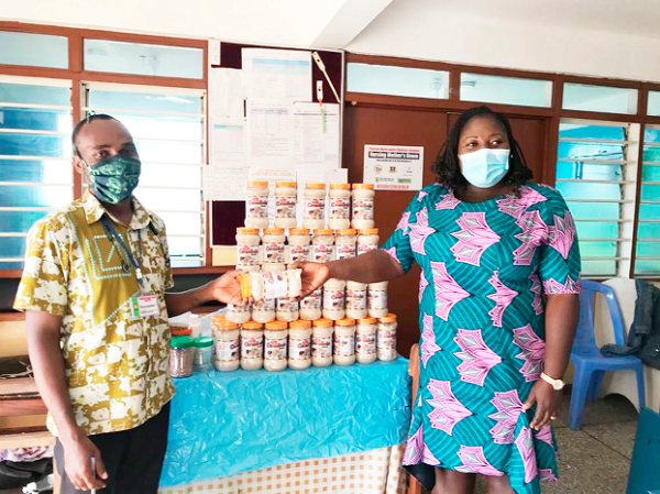  Mrs Linda Onyah Maka (right) handing over a bottle of Salbix cerealmix to Mr Wisdom Acheampong, the Assistant Administrator at the Princess Marie Louise Children’s Hospital