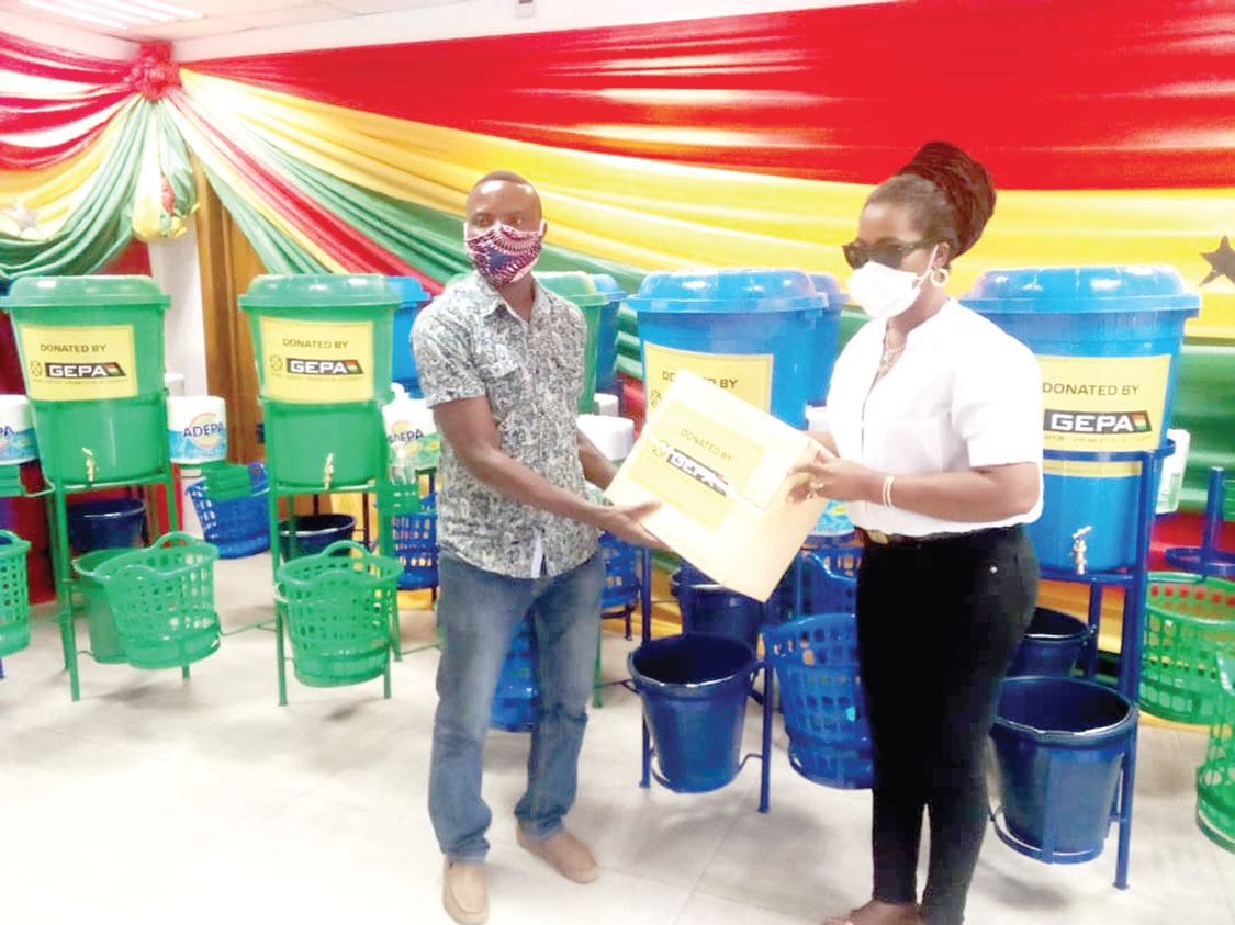 Ms Afua Asabea Asare (right),  presenting the PPE to  Mr Stephen Amofa,  a representative of Bonwire Kente producers