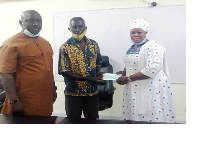  Hajia Zainab Sallow (right), the Ashanti Regional Manager of MASLOC, presenting a cheque to a beneficiary. On the far left is Mr Boris Baidoo, the Ashanti Regional Chairman of the Poultry Farmers Association