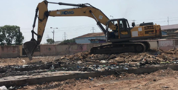 The bulldozer clearing conrete slabs to allow the leveling of the market 