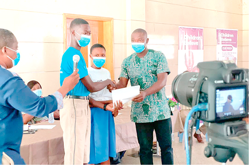Leaders of the Child-Friendly Accountability Mechanism Club presenting a copy of the communique they read at the forum to Mr Iddrisu Sandey (right), Northern Regional Director of the Department of Children, Ministry of Gender, Children and Social Protection