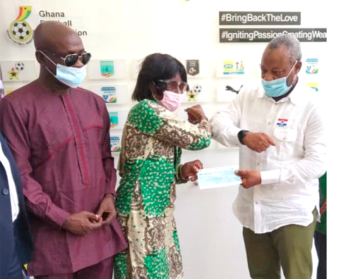 Madam Habiba Atta Forson, GFA Executive Council member, receiving the cheque from Mr Ahmed Osman Halid