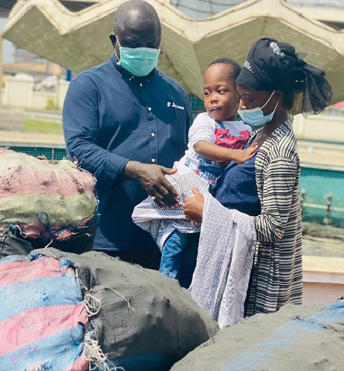 Mr. Samuel Nii Adjei Tawiah, MCE, KoKMA presenting bags of charcoal to one of the beneficiaries