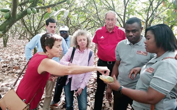  Ms Diana Acconcia (left) tasting a ripe cocoa bean on the farm during the visit. Holding the pod is Ms Deborah Kwablah, Corporate Communications & Public Affairs Manager of Nestle Coastal Cluster. Looking on are other members of the delegation. Picture: Kwadwo Baffoe Donkor