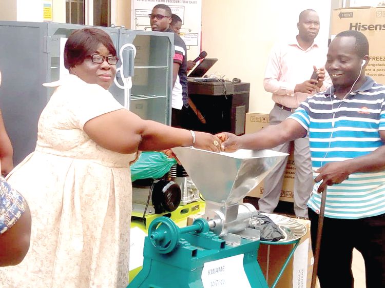  Ms Getrude Ankrah (left) presenting a fufu-making machine to one of the beneficiaries.