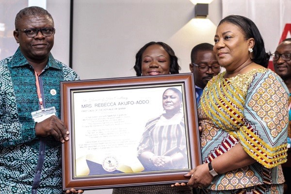 Dr John Adabie Appiah (left), President of the Paediatric Society of Ghana, presenting a citation to Mrs Rebecca Akufo-Addo in recognition of her continuous effort in ensuring quality child health in the country