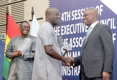 Mr Titus-Glover (middle), Deputy Minister, Transport, in a handshake with Mr Dakuku Peterside (right), Chairman, Association of African Maritime Administrations (AAMA), after delivering his speech.