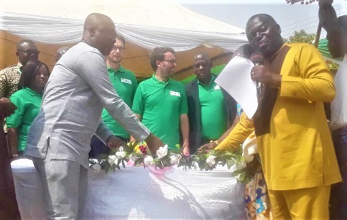 Mr Benito Owusu-Bio, (right) being assisted by the Bono East Regional Minister, Mr Kofi Amoakohene to launch the project