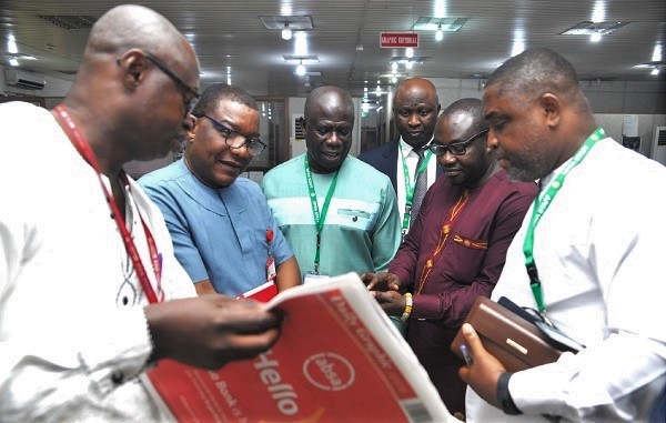 Mr Kobby Asmah (2nd left), Editor, Daily Graphic and Mr Enoch Darfah Frimpong, (2nd right), Assistant Online Editor at Graphic showing a copy of the digital version of the Daily Graphic on the Graphic Newsplus to Mr Hayford Atta Krufi (3rd left), CEO; Mr David Tetteh-Amey Abbey (right), Deputy CEO, and Mr James Addai, Director of Finance, all of the NPRA, during the visit.