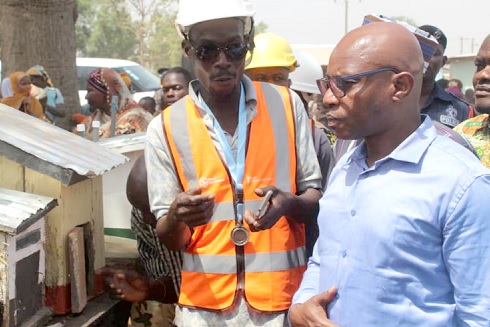 Mohammed Iddrisu, an artisan, showing Mr Michael Yaw Gyato (right) some samples of the WASH facilities