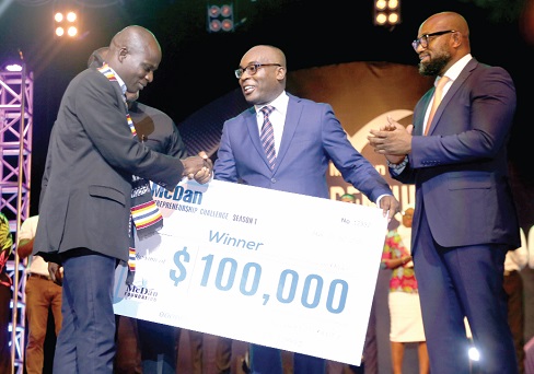 Mr Augustine Blay (middle), Executive Secretary to the Vice- President, presenting a dummy cheque for $100,000 to Mr Alhassan Koligu Hamza (left), Founder, Alkoh Shea, while Mr Daniel McKorley (right) applauds. 