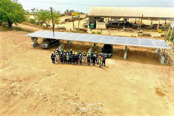 Some workers of the company standing infront of the solar panel after its inauguration 