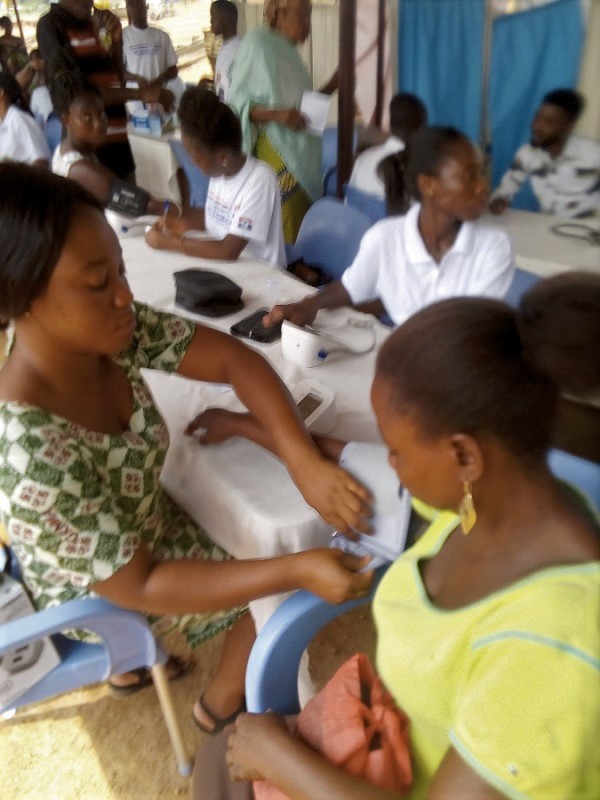 Ms Selina Amankwa (right) of Labolabo, a community in the constituency being attended to by a nurse