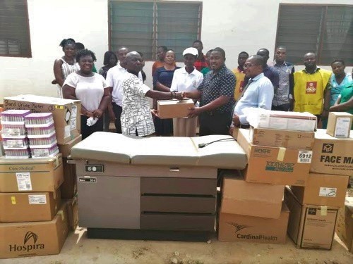 Mr Asamoah ( left ) handing over the items to Dr Bekui.  Looking on are some staff members of the health centre