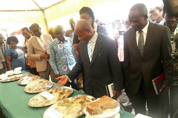 Prof Asare (2nd right) showing some pastries made from the new cowpea varieties to guests at the exhibition