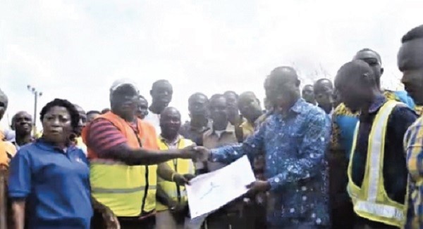 Mr Joseph Osei Owusu (3rd right), MP for Bekwai presenting map of the site for the lorry terminal, martket and the estate project to Mr Attachy (2nd left), the contractor at the construction site at Denyasi