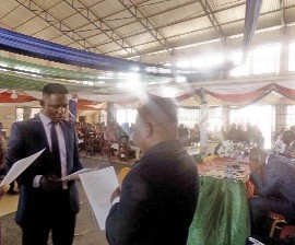 Mr Akwasi Apiatse Abaidoo, the Oda District Magistrate (right) swearing in Mr Enoch Ofori Aidoo at the ceremony