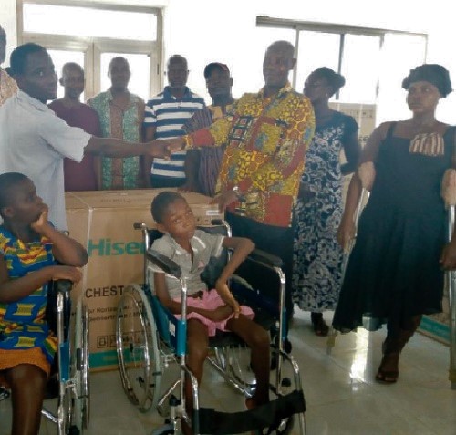 Mr Gabriel Dortumor receiving a table top fridge from Mr Adzoteye Lawer Akrofi, the DCE for Ada West 