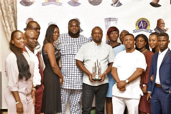 Mr Bright Korlie Matey (middle) displaying the award he received on behalf of his father while some staff of Freddie’s Corner look on