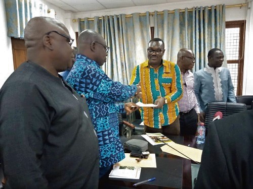 Mr Kwaku Asomah-Cheremeh (2nd left), Minister of Lands and Natural resource, receiving the cheque on behalf of the government.