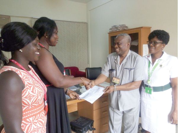 Ms Yvonne Aryee of the Corporate Communications Unit, GCGL, presenting the cheque to Mr Kombian Kambarin, the Deputy Director of Administration, Korle Bu Teaching Hospital. Those with them are Ms Janet Oppong of the GCGL (left) and Ms Comfort Gaituah, a principal nursing officer at the hospital