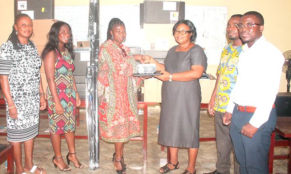 Ms Matilda Arhin (3rd left) presenting the items to Mrs Beatrice Akumiah, Head Teacher, Liberty Avenue '2’ Junior High School. Looking on are some staff of the school. Picture: Maxwell Ocloo