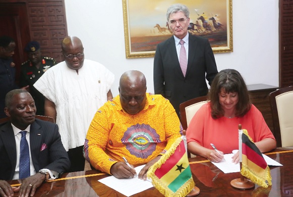Mr Jonathan Amoako-Baah, Chief Executive Officer, GRIDCo, and Ms Sabine Dall'Omo, CEO, Siemens Southern and Eastern Africa, signing the MoU.  Standing behind them are President Akufo-Addo and Mr Joe Kaeser (right). Picture: SAMUEL TEI ADANO­