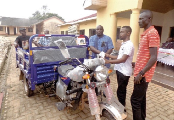 Mr Seth Birikorang-Ofosu (3rd right) presenting a motorised tricycle to Mr Albert Ampofo, a 25-year-old blind man from Akwatia.