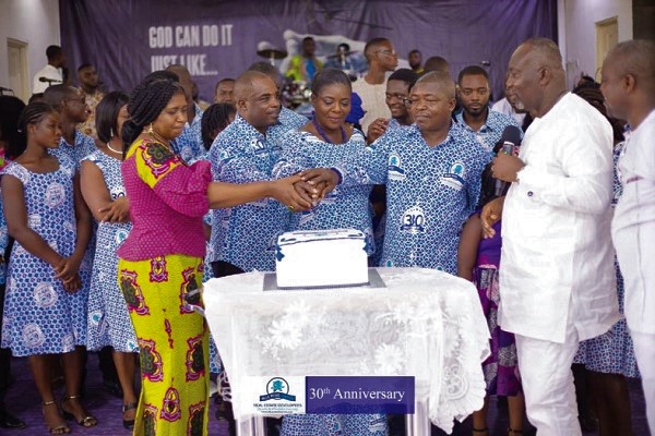 Mr Eric Ebo Acquah (2nd left) being joined by some staff staff  to cut the anniversary cake while Rev. Jeremiah Boateng (2nd right) of the Sureway Assemblies of God looks on