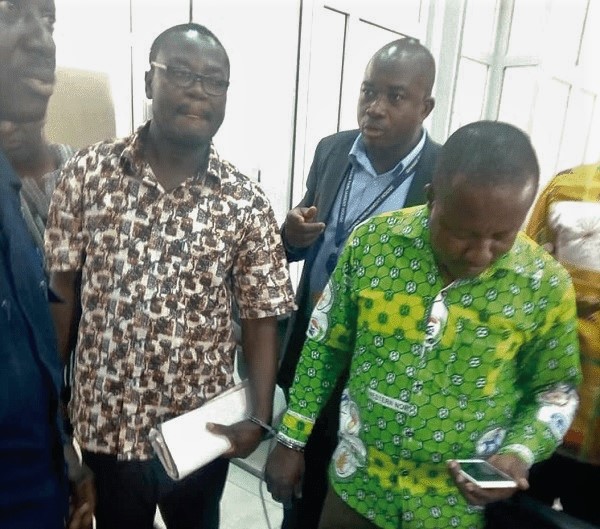 Isaac Akowuah (left), former District Finance Officer, and James Esilfie, the current officer, in handcuffs