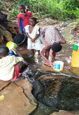 Children scooping water from the Ameselae stream
