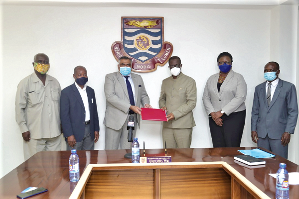 Professor Joseph Ghartey-Ampiah (3rd right) exchanging documents with Mr Lalit Mishra (3rd left) after signing the agreement on behalf of their  respective organisations