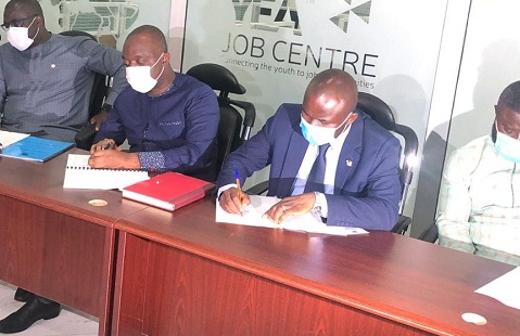 The YEA boss, Justin Kodua (middle) and Director General at the NSA, Prof. Peter Twumasi (right) signing the agreement