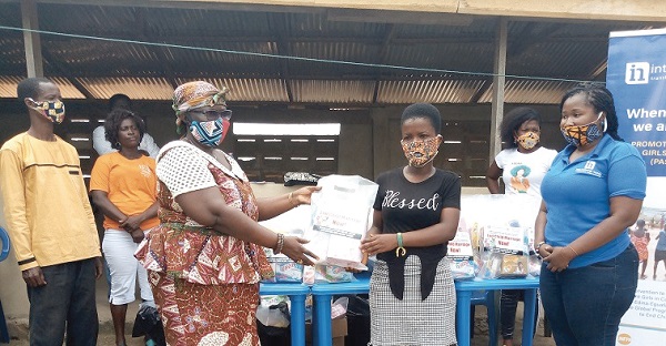 Nana Afua Badu (left), queenmother of Kissi, presenting a pack to Faustina Arkromond, a beneficiary