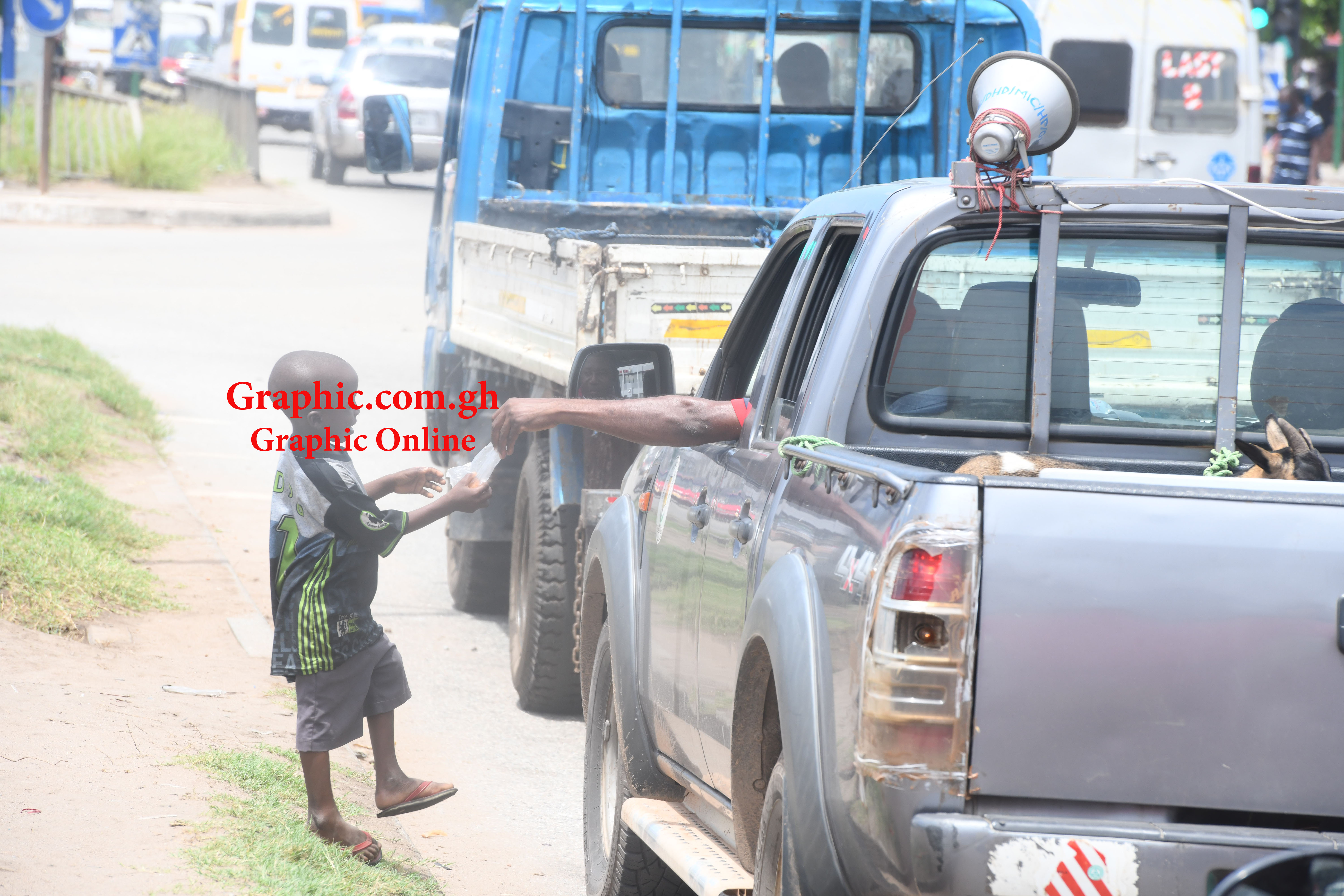 A  motorist dropping food for a child on the Graphic Road. Pictures: EMMANUEL QUAYE