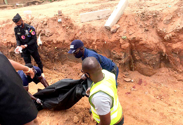 Policemen conveying the body of one of the workers from the site at Ashongman