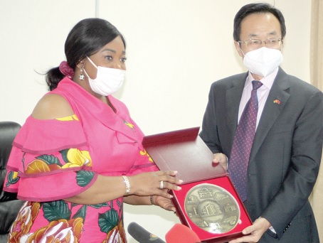 Ms Shirley Ayorkor Botchwey (left), Minister of Foreign Affairs and Regional Integration, presenting a gift to Mr Shi Ting Wang (right), the outgoing Chinese Ambassador to Ghana during a farewell call on the former at her office in Accra.