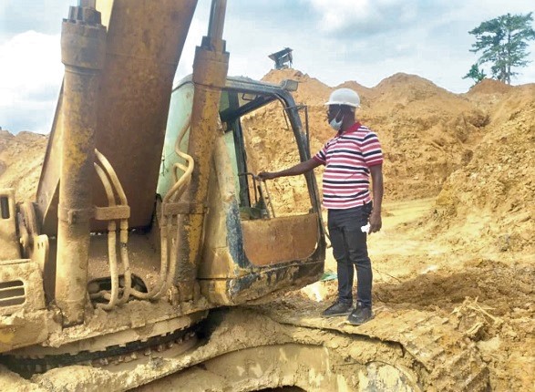 Mr Asomah-Cheremeh standing by one of the excavators