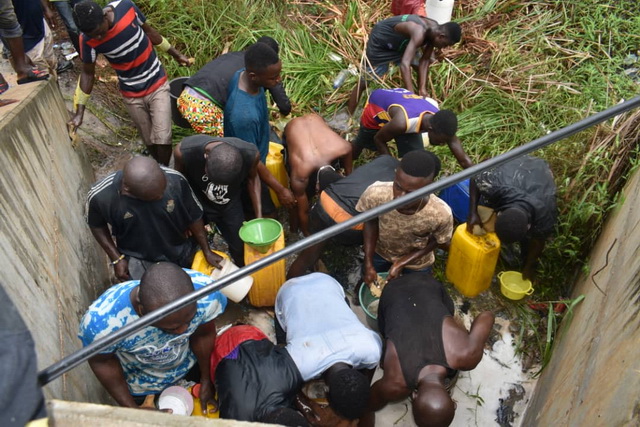 Young men salvaging fuel from an accident scene 