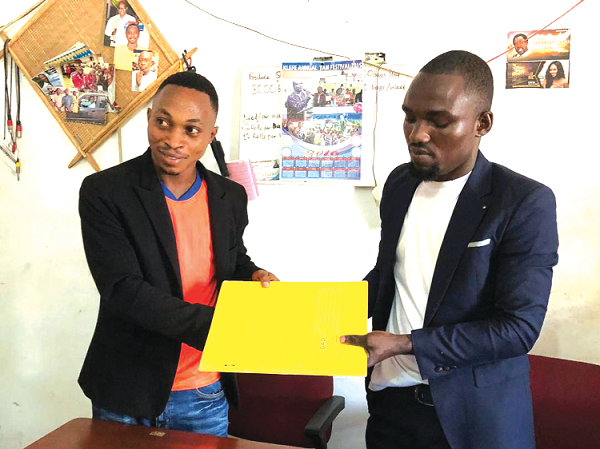  Eric Adzie (LEFT) holds contract document with Christian Sowada of EX TV