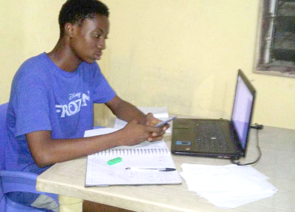 A first year student of UPSA taking his online exams at home